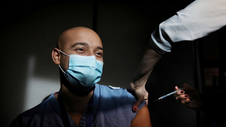 Le médecin Alister Martin reçoit l'une des premières doses du vaccin contre la maladie à coronavirus Pfizer-BioNTech (COVID-19) de la RN Jennifer Lisciotti au Massachusetts General Hospital de Boston, Massachusetts, États-Unis, le 16 décembre 2020. Craig F. Walker / Pool via REUTERS IMAGES TPX DU JOUR