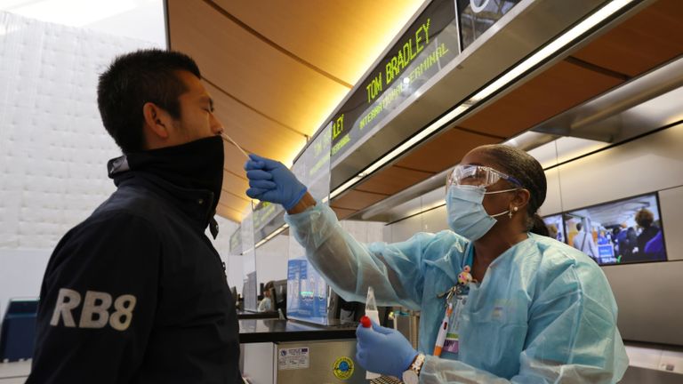 Scott Fujii, 34 ans, reçoit un test de coronavirus rapide de 24 heures par l'infirmière Caren Williams au terminal international Tom Bradley de l'aéroport de LAX afin qu'il puisse se rendre à Hawaï pour voir sa famille, alors que l'épidémie mondiale de la maladie à coronavirus (COVID-19) se poursuit , à Los Angeles, Californie, États-Unis, 23 novembre 2020. REUTERS / Lucy Nicholson