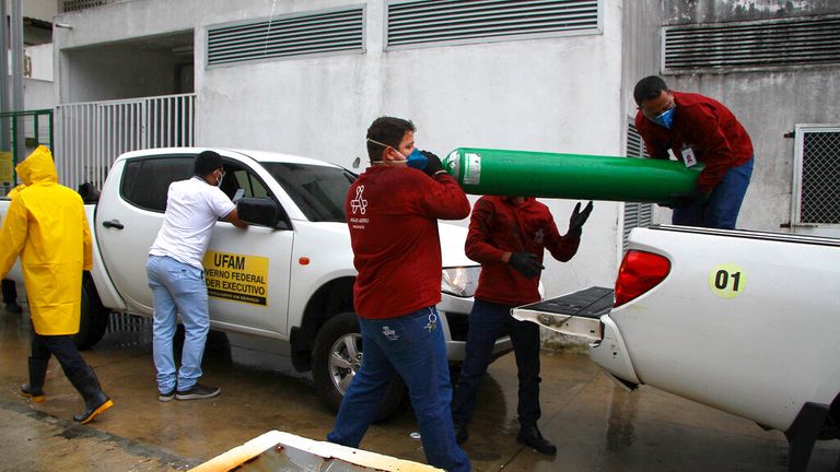 Les travailleurs de l'Université fédérale d'Amazonas transportent des réservoirs d'oxygène vides à l'hôpital Getulio Vargas en raison de pénuries