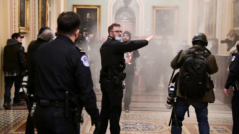 Un agent de sécurité fait signe après que des partisans du président américain Donald Trump ont enfreint les défenses de sécurité au Capitole américain, à Washington, aux États-Unis, le 6 janvier 2021. REUTERS / Mike Theiler