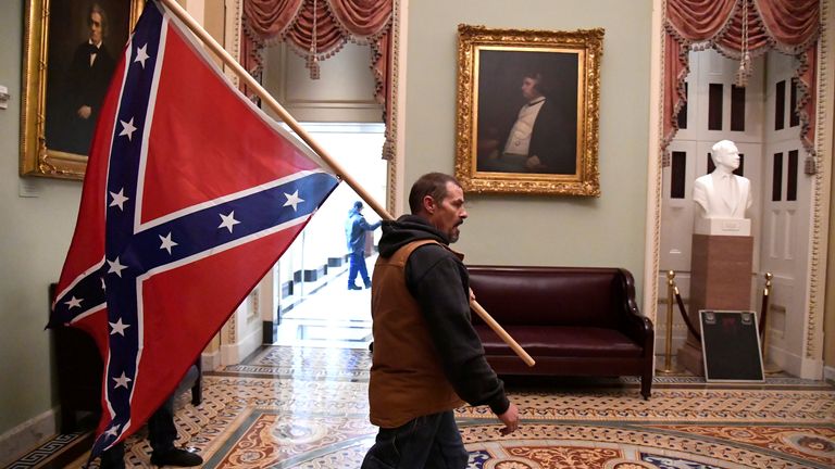 Un partisan du président Donald Trump mène une bataille de conférence au deuxième étage du Capitole américain près de l'entrée du Sénat après avoir enfreint les défenses de sécurité, à Washington, États-Unis, le 6 janvier 2021. REUTERS / Mike Theiler