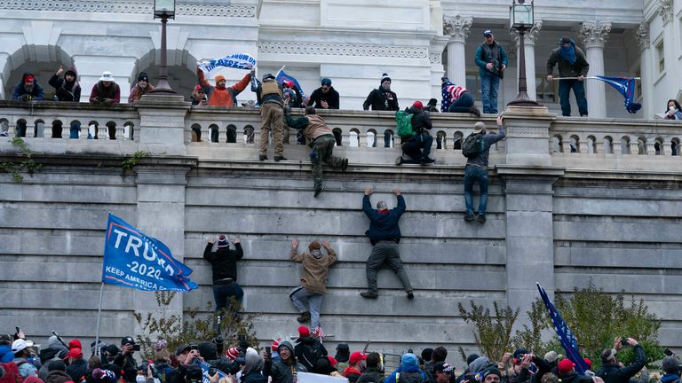 Les partisans du président Donald Trump escaladent le mur ouest du Capitole américain le mercredi 6 janvier 2021 à Washington.  (Photo AP / Jose Luis Magana)