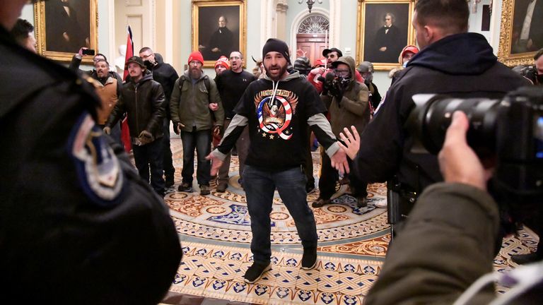 Un partisan du président Donald Trump affronte la police alors que les partisans de Trump manifestent au deuxième étage du Capitole américain près de l'entrée du Sénat après avoir enfreint les défenses de sécurité, à Washington, États-Unis, le 6 janvier 2021. REUTERS / Mike Theiler