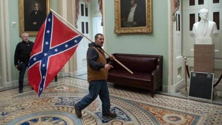 Cet homme a été vu portant un drapeau confédéré à l'entrée de la chambre du Sénat