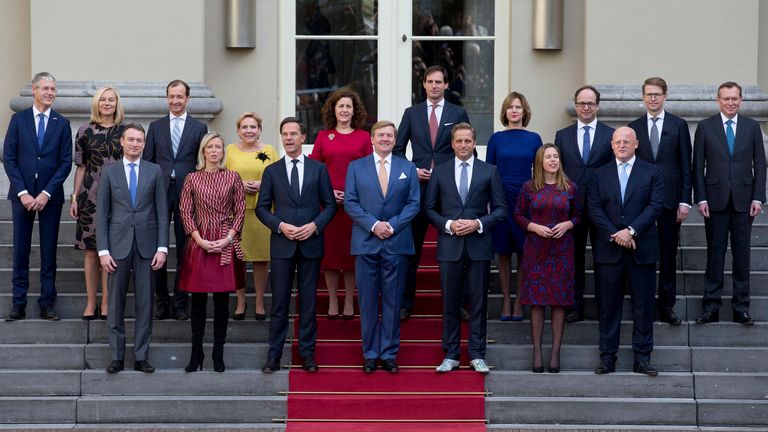 DOSSIER - Dans ce jeudi 26 octobre 2017, photo d'archive, le Premier ministre Mark Rute, au centre gauche, et le roi néerlandais Willem-Alexander, au centre, posent avec les ministres pour la photo officielle du nouveau gouvernement néerlandais sur les marches de Royal Palace Noordeinde à La Haye, Pays-Bas.  Le cabinet néerlandais se réunissait le vendredi 15 janvier 2021, au milieu de fortes spéculations selon lesquelles le gouvernement du Premier ministre Mark Rutte démissionnerait pour assumer la responsabilité politique d'un scandale impliquant des enquêtes sur les allocations familiales (AP Photo
