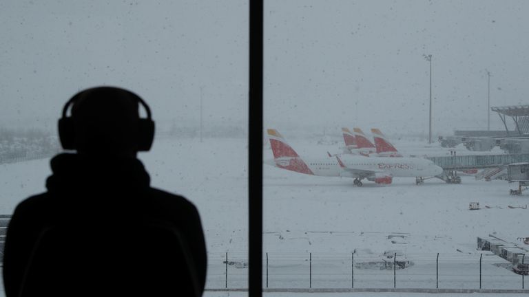 Une personne observe des avions stationnés à l'aéroport Adolfo Suarez Barajas, qui suspend ses vols en raison de fortes chutes de neige