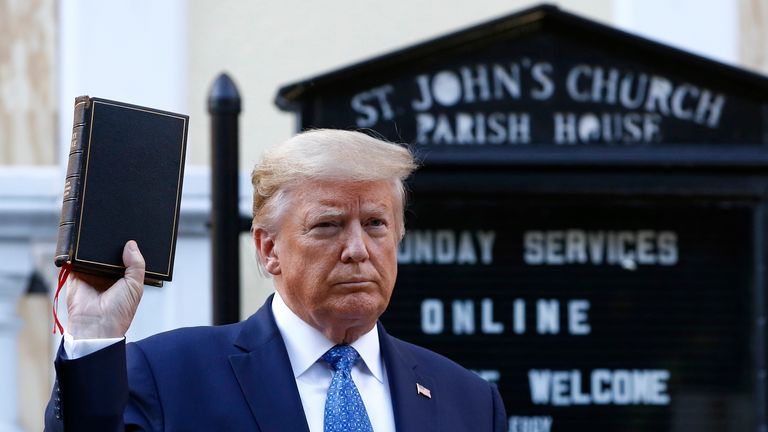 Le président Donald Trump tient une Bible lors de sa visite à l'extérieur de l'église Saint-Jean de l'autre côté du parc Lafayette depuis la Maison Blanche le lundi 1er juin 2020 à Washington.  Une partie de l'église a été incendiée lors de manifestations 