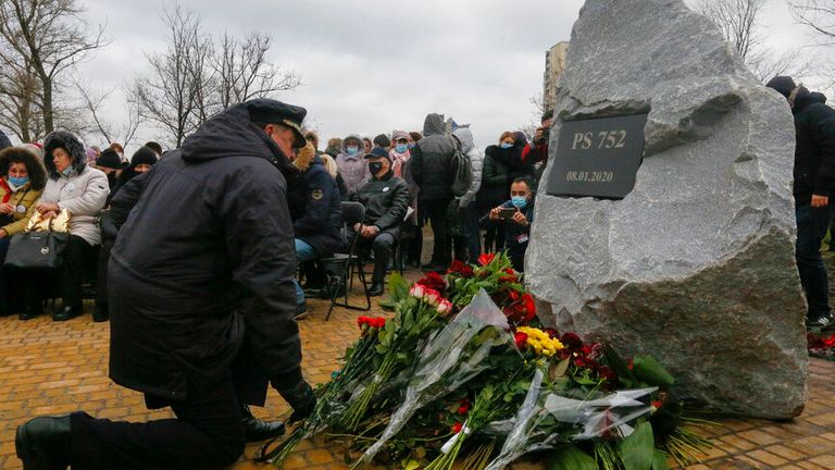 Un pilote dépose des fleurs à un mémorial à Kiev, en Ukraine, vendredi 8 janvier 2021, pour les victimes d'un accident d'avion ukrainien 737-800 à la périphérie de Téhéran.  (Photo AP / Efrem Lukatsky)