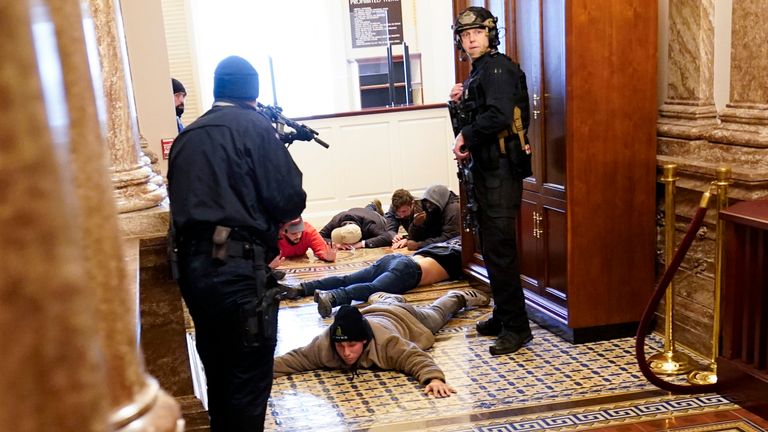 La police du Capitole des États-Unis a arrêté des manifestants à la pointe d'une arme près de la salle de la Chambre à l'intérieur du Capitole américain le mercredi 6 janvier 2021 à Washington.  (Photo AP / Andrew Harnik)