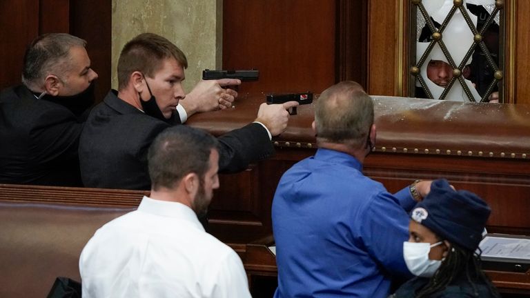 La police du Capitole des États-Unis, les armes à feu, observe les manifestants qui tentent de s'introduire dans la salle de la Chambre du Capitole des États-Unis le mercredi 6 janvier 2021 à Washington.  (Photo AP / J. Scott Applewhite)                                                                                                       