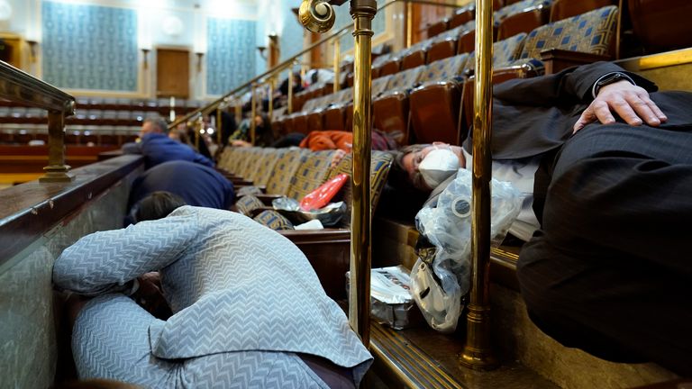 Les gens s'abritent dans la galerie de la Chambre alors que les manifestants tentent de pénétrer par effraction dans la salle de la Chambre du Capitole des États-Unis le mercredi 6 janvier 2021, à Washington.  (Photo AP / Andrew Harnik)                                                                                       