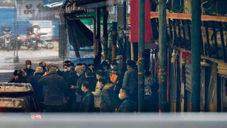 Des membres de l'équipe de l'Organisation mondiale de la santé enquêtant sur les origines de la pandémie de coronavirus arrivent sur le marché de gros de fruits de mer de Huanan à Wuhan, en Chine, le 31 janvier 2021 (Kyodo via AP Images) == Kyodo