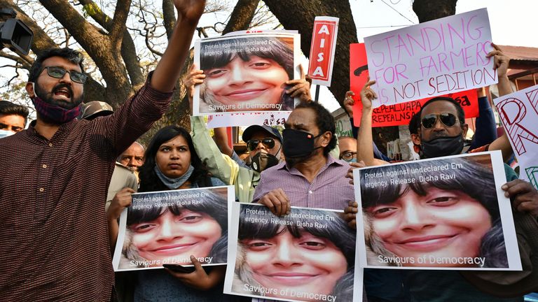 Des gens tiennent des pancartes et des photos de Disha Ravi lors d'une manifestation à Bengaluru
