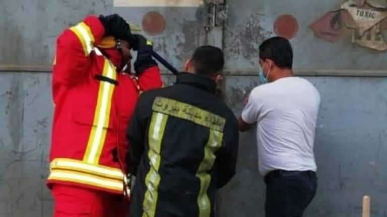 Photo de trois personnes essayant d'ouvrir le hangar 12. L'homme au t-shirt blanc sur le côté droit est Imad Zahereldine qui a été l'un des premiers sur les lieux à essayer d'éteindre le feu dans le hangar 12 du port.  Cela a été pris quelques instants avant l'explosion. 