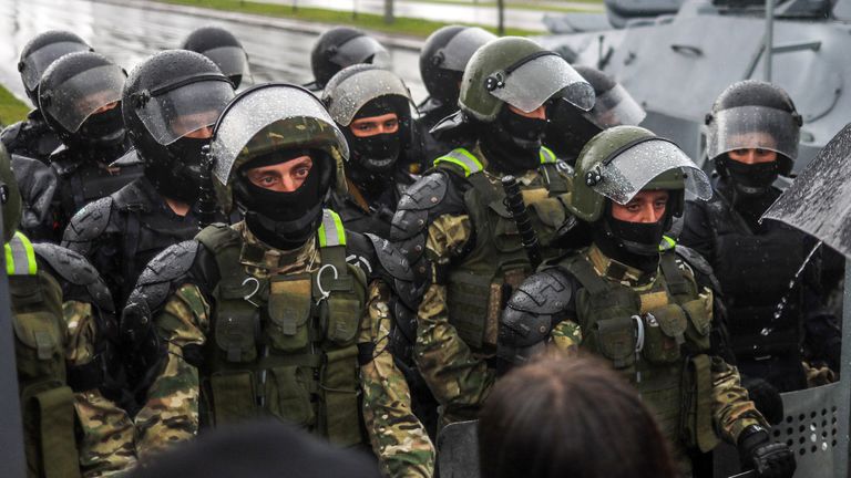 Des policiers anti-émeute bloquent une rue lors d'un rassemblement dimanche