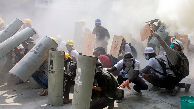 Les manifestants se mettent à l'abri alors qu'ils affrontent des policiers anti-émeute
