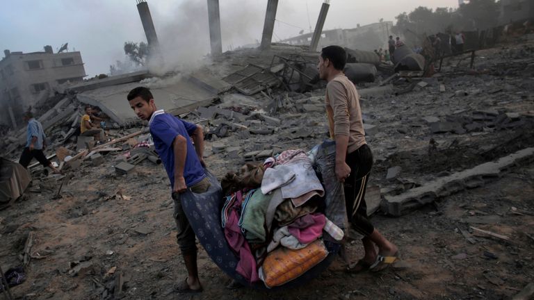 Des Palestiniens près de leur maison en ruine détruite par une frappe aérienne israélienne durant la nuit dans la ville de Gaza en juillet 2014                                                                                                                                                                                                    