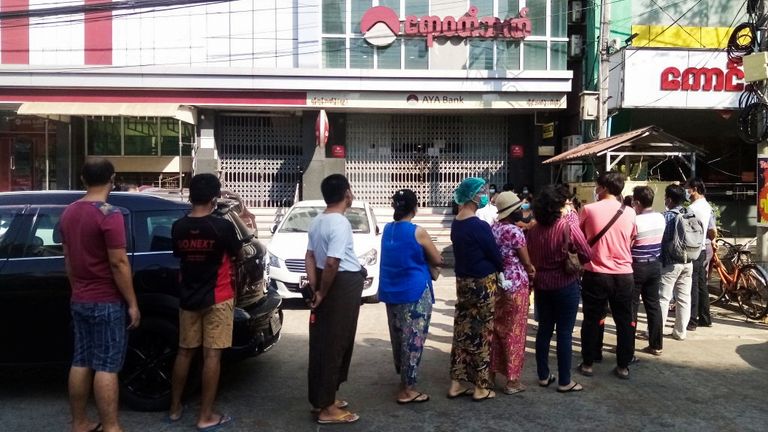 Les gens font la queue devant une succursale bancaire à Yangon, Myanmar