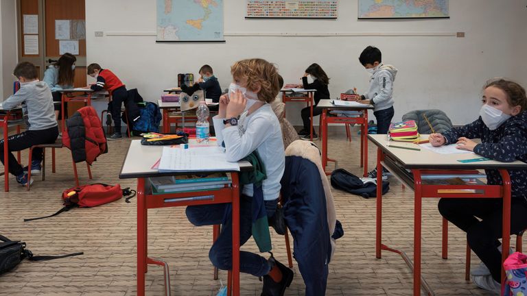 Des élèves de l'école primaire italienne, portant des masques, sont assis à distance les uns des autres pendant une leçon alors qu'ils retournent en classe après les vacances, à Santo Stefano Lodigiano, Italie, 7 janvier 2021