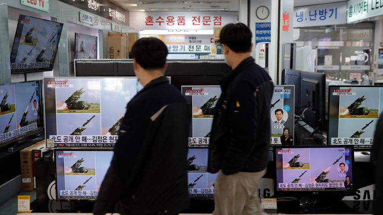 Des gens passent près d'écrans de télévision montrant un programme d'information sur les missiles de la Corée du Nord avec des images de fichiers dans un magasin d'électronique à Séoul, en Corée du Sud, le mercredi 24 mars 2021. Pic: AP