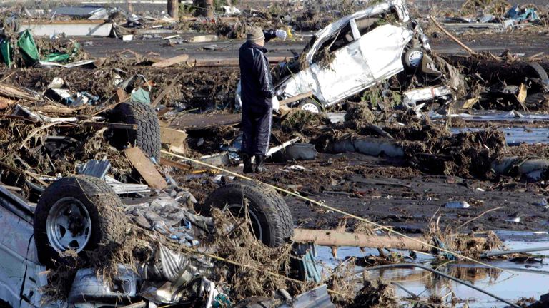 Un homme examine les dégâts causés par un tremblement de terre dans la ville de Minami Souma, préfecture de Fukushima