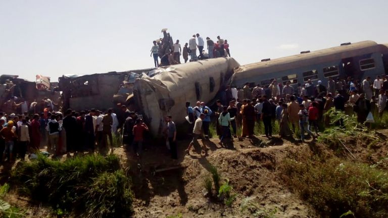 Les gens inspectent les dégâts après la collision de deux trains près de la ville de Sohag, en Égypte, le 26 mars 2021. REUTERS / Stringer PAS DE REVENTE.  PAS D'ARCHIVES
