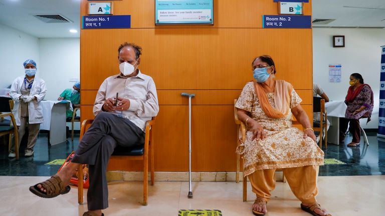 Un couple de personnes âgées attend leur tour alors qu'ils sont assis devant une salle de vaccination, à l'hôpital Max Super Specialty, au milieu de la pandémie de coronavirus (COVID-19), à New Delhi, Inde, le 17 mars 2021. REUTERS / Adnan Abidi
