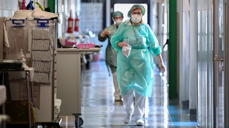 Les travailleurs médicaux portant des masques de protection et des combinaisons dans un hôpital de Crémone, Italie