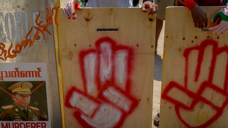 Les manifestants anti-coup d'État portaient des boucliers de fortune marqués d'un salut à trois doigts et d'une image dégradée du commandant en chef, le général Min Aung Hlaing 