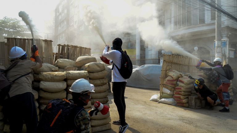 Des manifestants anti-coup d'État pulvérisent des extincteurs sur une barricade à Yangon