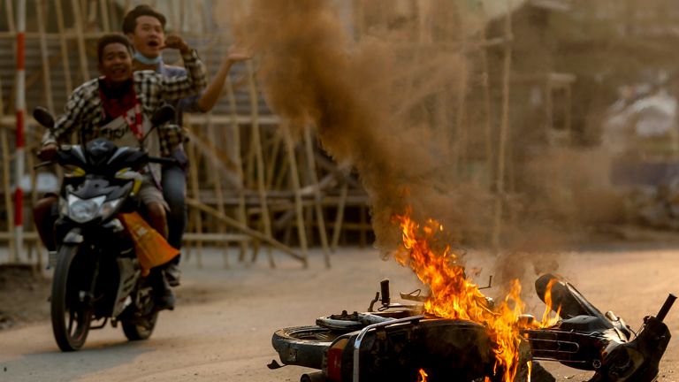 Deux hommes à moto préviennent que les forces de sécurité des manifestants viennent à une manifestation à Mandalay.  Pic: AP