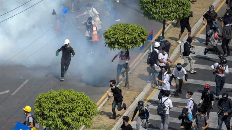 Des manifestants fuient des cartouches de gaz lacrymogène lors d'une manifestation contre le coup d'État militaire à Yangon