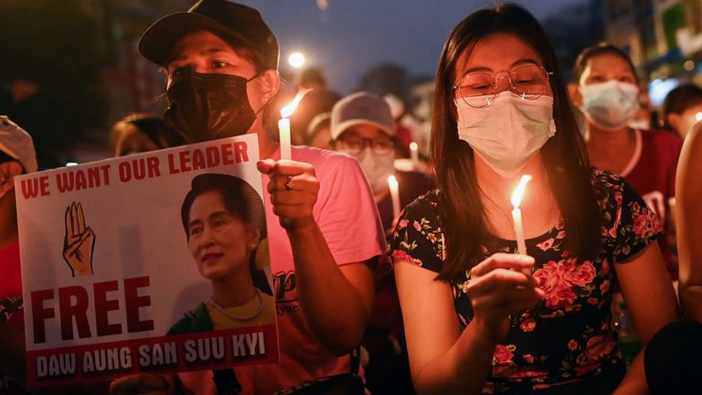 Des gens tiennent des bougies alors qu'ils participent à une manifestation nocturne anti-coup d'État à Yangon