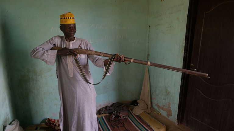 Lawani Adali, l'agent de sécurité en service le jour, avec son arme Dane, explique son expérience le jour où plus de 300 filles ont été enlevées par des hommes armés de l'école secondaire gouvernementale de filles, dans la ville de Jangebe, dans l'État de Zamfara, dans le nord du Nigéria, lundi, 1er mars 2021. Adali a déclaré que les policiers et les justiciers ne pouvaient pas entrer parce que les hommes armés bloquaient partout, il y avait des tirs violents alors qu'ils criaient 