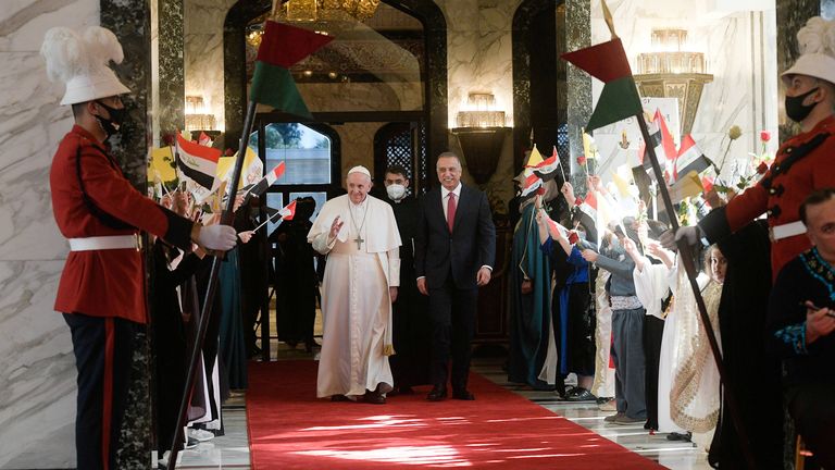 Le Premier ministre irakien Mustafa Al-Kadhimi marche avec le pape François à son arrivée à l'aéroport international de Bagdad