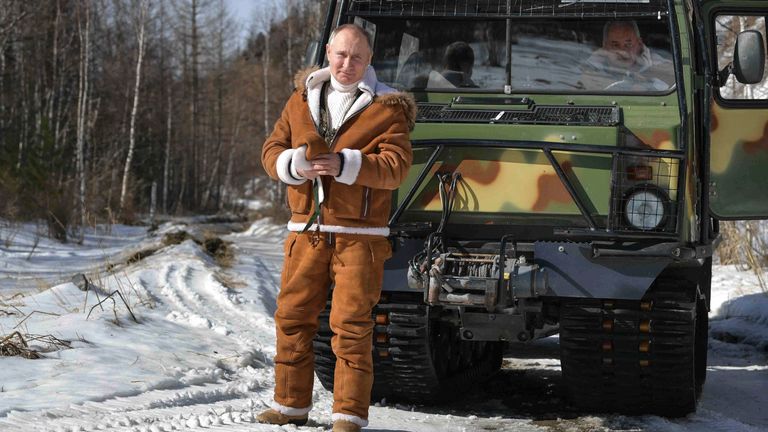   Poutine pose pour une photo devant un véhicule tout-terrain à chenilles