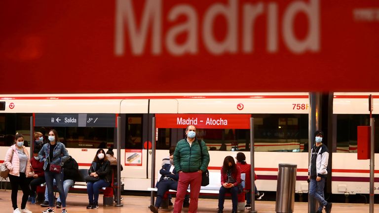 Les banlieusards portent des masques protecteurs attendent sur une plate-forme à la gare d'Atocha à Madrid