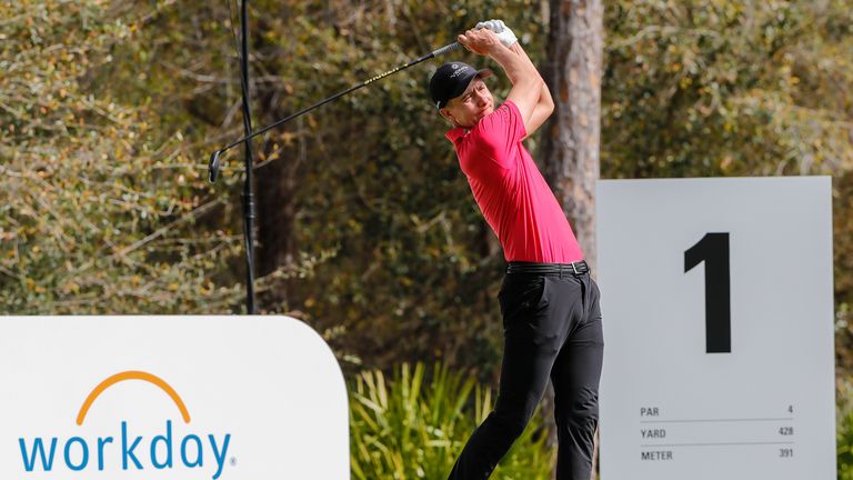 Carlos Ortiz joue son tir du premier tee habillé en rouge et noir pour soutenir Tiger Woods 