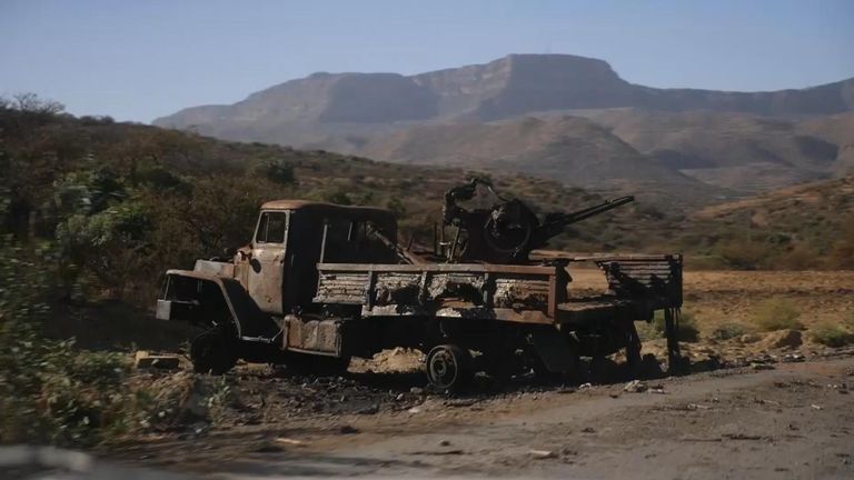 Des camions et du matériel militaire brûlés sont éparpillés sur le bord de la route