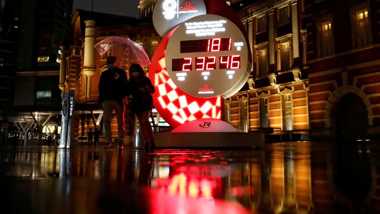 Les passants passent devant un compte à rebours avant les Jeux