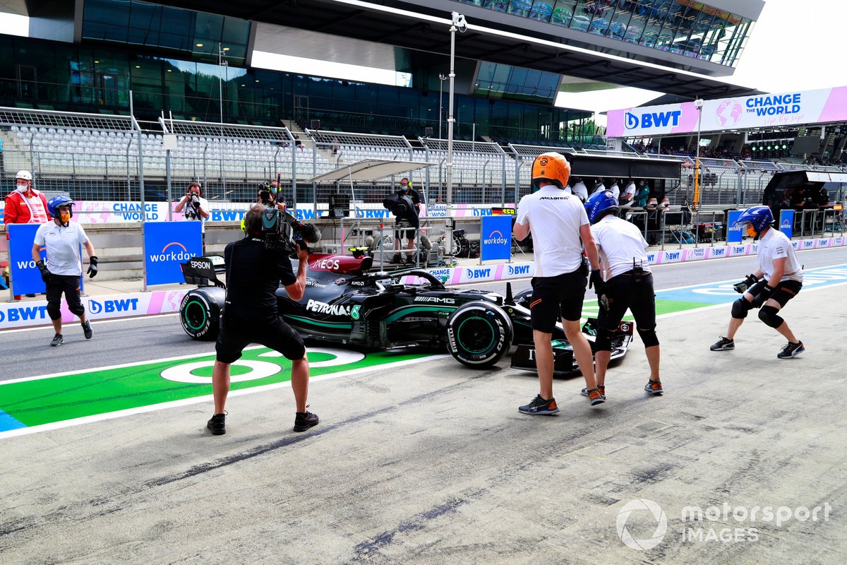 Les membres de l'équipe des stands McLaren tentent d'aider Valtteri Bottas, Mercedes W12, dans la voie des stands