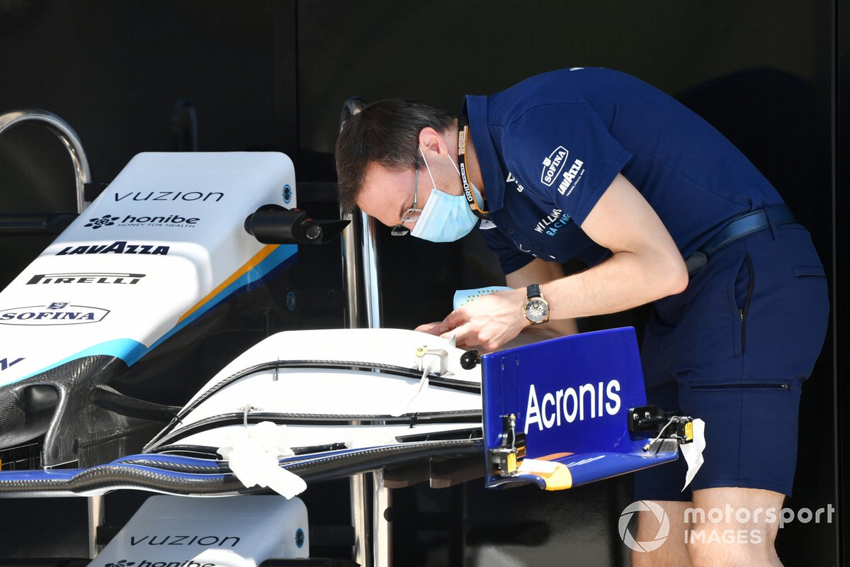 Un mécanicien ajuste un aileron avant appartenant à une Williams FW43B 