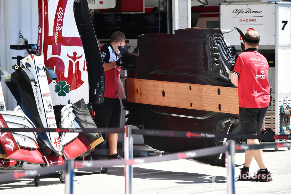 Des mécaniciens transportent le sol d'une Alfa Romeo Racing C41 dans le garage de l'équipe