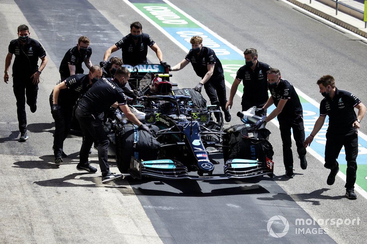 Des mécaniciens déplacent la voiture de Valtteri Bottas, Mercedes W12