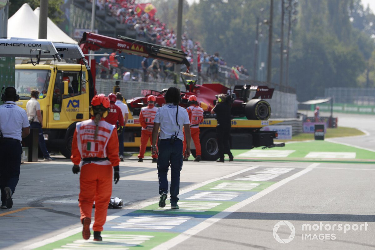 Les maréchaux ramènent la voiture de Carlos Sainz Jr., Ferrari SF21, aux stands