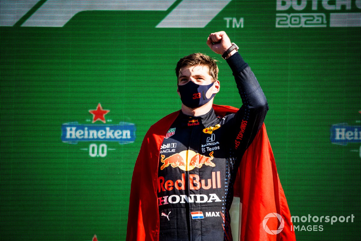 Max Verstappen, Red Bull Racing, 1ère position, porte un drapeau néerlandais en guise de cape sur le podium